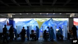 Trabajadores de la salud preparan dosis de la vacuna Sputnik V en un centro de vacunación instalado en el estacionamiento del Instituto de Previsión Social de las Fuerzas Armadas (IPSFA) en Caracas, Venezuela, 7 de junio de 2021