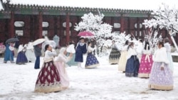 Para pengunjung menikmati salju di Istana Gyeongbok di Seoul, salah satu dari tempat populer di Korea Selatan, Rabu, 27 November 2024. (Foto: Lee Jin-man/AP Photo)