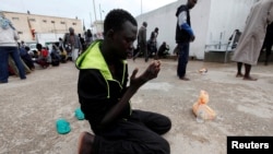 FILE - An illegal African migrant prays at a detention camp in Tripoli, Libya, March 22, 2017. Norway has agreed to take 600 asylum-seekers evacuated to Rwanda from Libya.