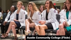 FILE- Austin Community College students who completed the nursing associate degree program participate in a pinning ceremony, May 10, 2017.