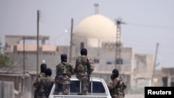 FILE - Syrian Democratic Forces are seen in Raqqa, Syria, July 31, 2017.