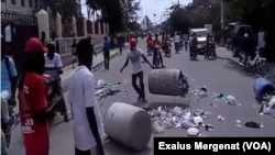 Protesters throw trash on street during a demonstration against President Jovenel Moise in Gonaïves, Haiti, June 14, 2019. 