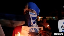 Un manifestante enmascarado participa en una vigilia a la luz de las velas en protesta por los presos políticos y las víctimas en las protestas contra el gobierno del presidente nicaragüense Daniel Ortega el año pasado.