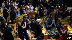 United Nations members stand up and applaud after a vote on a resolution concerning the Ukraine during an emergency meeting of the General Assembly at United Nations headquarters, Wednesday, March 2, 2022. (AP Photo/Seth Wenig)