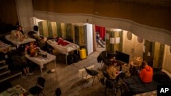 Displaced Ukrainians take shelter in an auditorium in Lviv, Ukraine, March 2, 2022. Russian forces have escalated their attacks on crowded urban areas in the country.