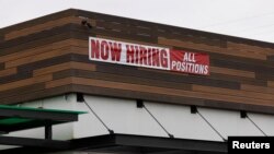 FILE - A restaurant advertising jobs looks to attract workers in Oceanside, California, May 10, 2021. 
