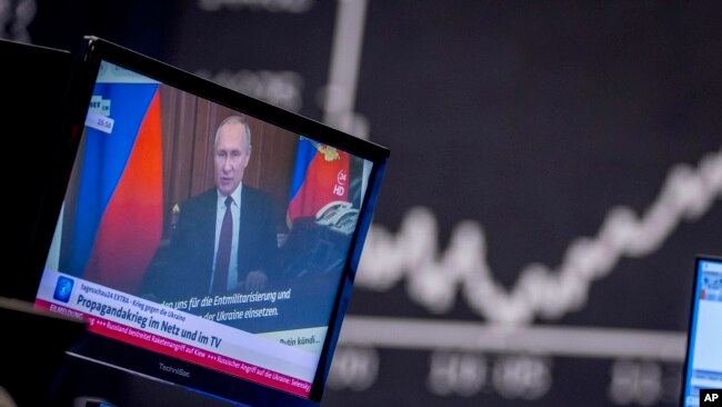 In this file photo, Russia's President Vladimir Putin appears on a television screen at the stock market in Frankfurt, Germany, Feb. 25, 2022. (AP Photo/Michael Probst, File)