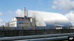 FILE - A shelter construction covers the exploded reactor at the Chernobyl nuclear plant, in Chernobyl, Ukraine, on April 27, 2021.