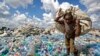 FILE - A man walks on a mountain of plastic bottles as he carries a sack of them to be sold for recycling after weighing them at the dump in the Dandora slum of Nairobi, Kenya, on Dec. 5, 2018. 