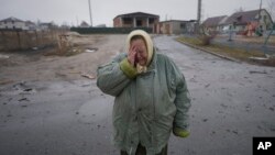 A woman cries outside houses damaged by a Russian airstrike, according to locals, in Gorenka, outside the capital Kyiv, Ukraine, March 2, 2022. 