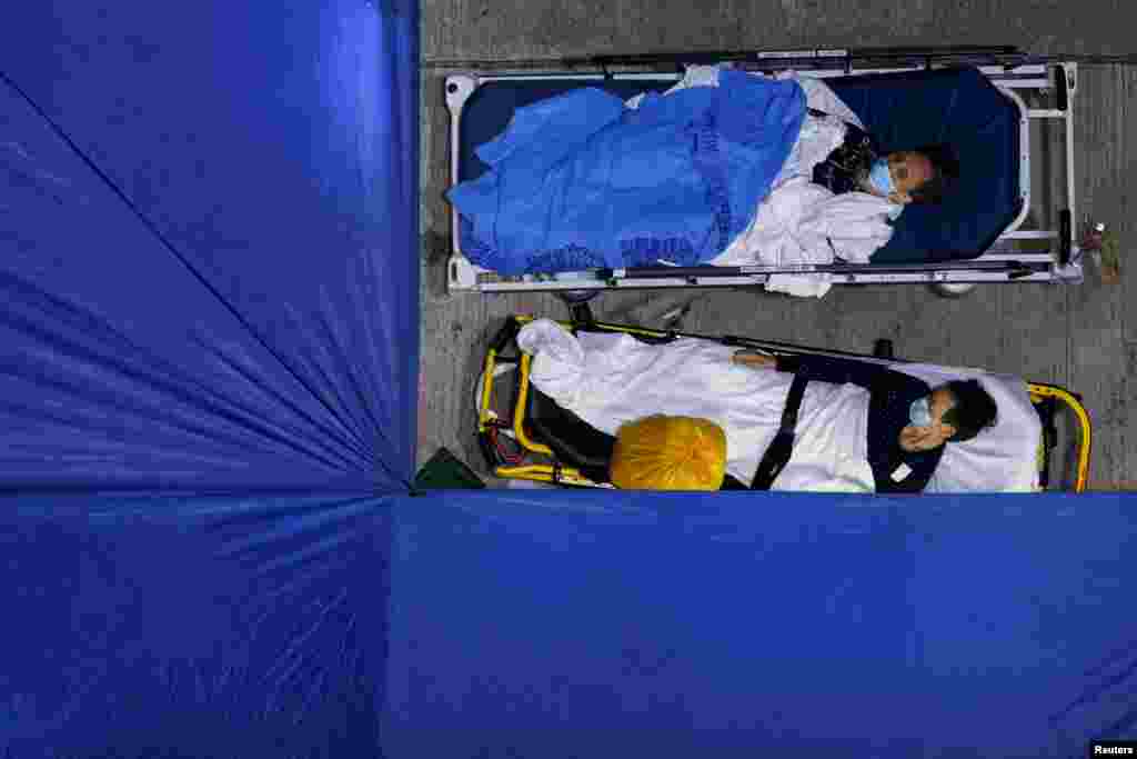 Patients sleep at a temporary COVID-19 treatment area, outside a hospital in Hong Kong, March 1, 2022.