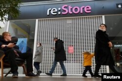 Orang-orang berjalan melewati toko Apple yang tutup di sebuah mal di Omsk, Rusia 2 Maret 2022. (Foto: REUTERS/Alexey Malgavko)