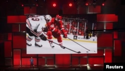 FILE - An EA Sports representative demonstrates a hockey game at the Electronic Arts (EA) World Premiere at the Shrine Auditorium in Los Angeles, California, June 9, 2014.