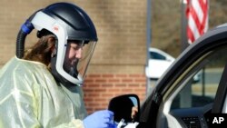 FILE - Nurse Jordan Ledbetter performs a test for COVID-19 outside the Marion County Health Department in Hamilton, Alabama, Feb. 15, 2022.