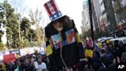 4일 이란 테헤란에 있던 과거 미국 대사관 앞에서 이란 학생들이 미국 대사관 점거사건 39주년을 기념하여 모인 가운데 학생들이 "타도 미국(Don with U.S.A.)"가 적힌 모자를 쓴  '엉클 샘' 모형을 들고 행진하고 있다.    