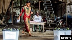 A voter prepares to cast her ballot at a polling station in the Madina neighbourhood of Guinea's capital Conakry, Sep. 28, 2013. 