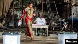 Une électrice s’apprêtant à déposer son bulletin dans un bureau de vote dans le quartier Madina de la capitale guinéenne, Conakry, le 28 septembre 2013. 