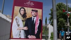 A poster featuring Crown Prince Hussein and his fiancee, Saudi architect Rajwa Alseif, is displayed at the main road in downtown Amman, Jordan, May 30, 2023.