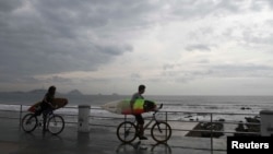 Surfers arrive at El Camaron beach before paddling out into the surf generated by tropical storm Sonia in Mazatlan, in the Mexican state of Sinaloa November 3, 2013. 