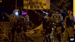 Police in riot gear react to protesters near the University of Hong Kong, in Hong Kong, Nov. 16, 2019. 
