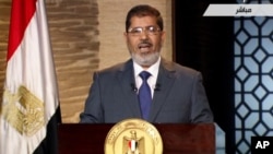 In this image taken from Egypt State TV, newly-elect President Mohammed Morsi delivers a speech in Cairo, Egypt, Sunday, June 24, 2012. In his first televised speech on state TV, Morsi pledged Sunday to preserve Egypt's international accords, a reference
