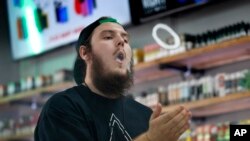 Devin Lambert, manajer toko rokok elektrik Good Guys Vape, menunjukkan keahlian menggunakan rokok elektrik, Biddeford, Maine, 3 September 2019. (Foto: Associated Press)