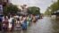 Residents wade through a flooded street as they evacuate their homes in Chennai, in the southern state of Tamil Nadu, India, Dec. 3, 2015. 