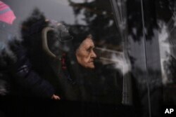 A woman fleeing from Ukraine looks out a bus window as she arrives at a temporary shelter run by the municipality and the Baptist Charity in Tiszabecs, Hungary, March 4, 2022.