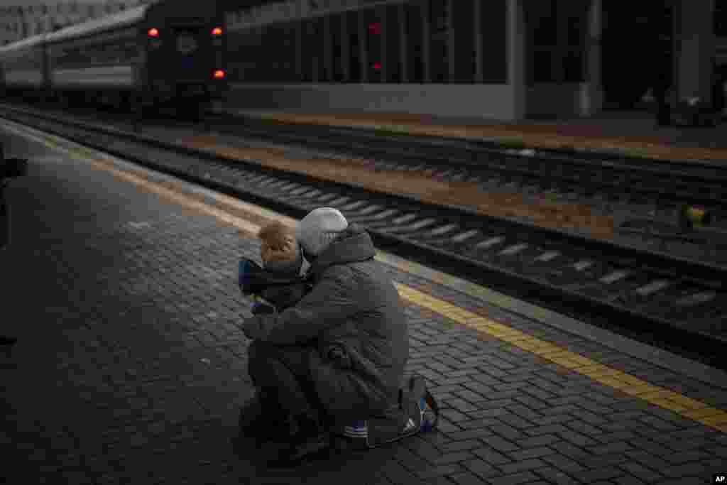 Una mujer y su hijo miran un tren que se va en la estación de Kiev, Ucrania, el jueves 3 de marzo de 2022. Mientras las mujeres y los niños abandonan la capital hacia lugares seguros, los hombres tienen que permanecer y luchar contra la invasión rusa. (Foto AP/Emilio Morenatti)