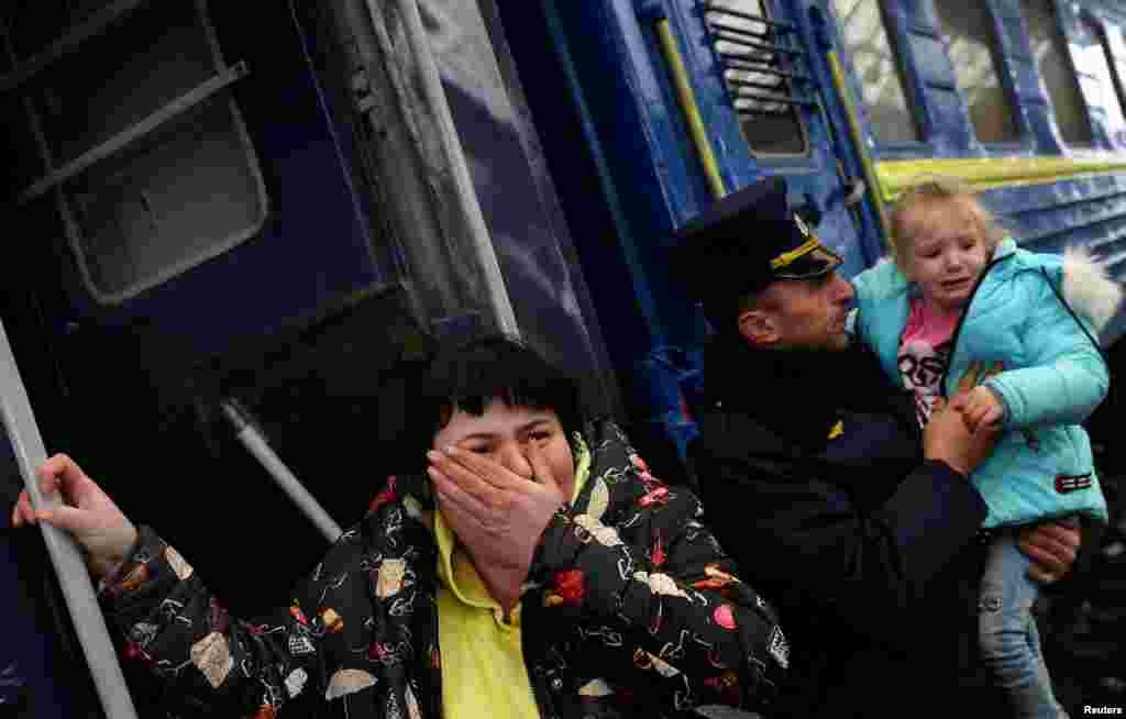 Una mujer y una niña reaccionan al no poder abordar de inmediato un tren que parte hacia Polonia luego de la invasión rusa de Ucrania en la estación principal de trenes en Lviv, Ucrania, el 4 de marzo de 2022.