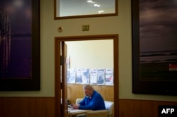 FILE - Russian investigative newspaper Novaya Gazeta's editor-in-chief Dmitry Muratov uses his smartphone at the independent media outlet's editorial office in Moscow, March 24, 2021.