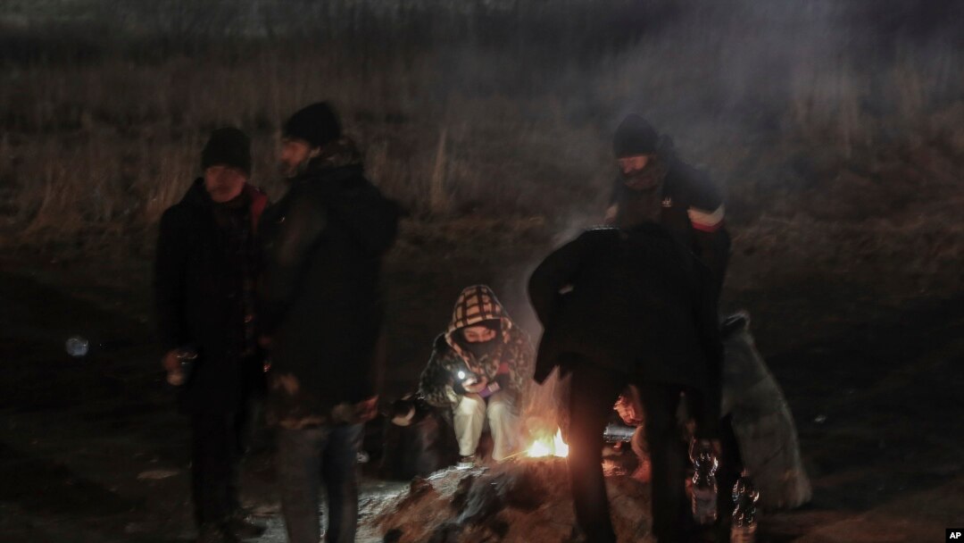 Siswa berkumpul di sekitar api unggun untuk menghangatkan diri di perbatasan Medyka setelah melarikan diri dari Ukraina, di Polandia, Senin, 28 Februari 2022. (Foto: AP)