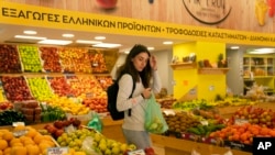 FILE - Personal trainer Antonia Kalantzi, 38, shops at a grocery store in Athens, Feb. 16, 2022.