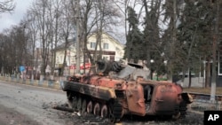 Un vehículo blindado de transporte de personal destruido se encuentra en la plaza central de la ciudad de Makariv, 60 kilómetros al oeste de Kiev, Ucrania, después de una dura batalla nocturna el viernes 4 de marzo de 2022. (Foto AP/Efrem Lukatsky)