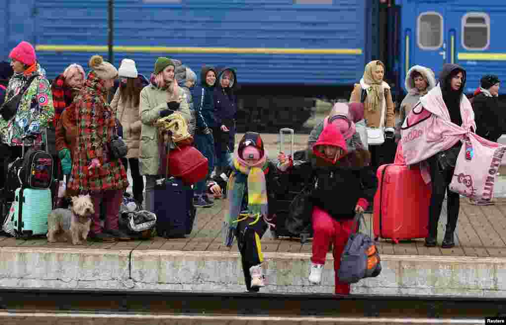 Refugiados cruzando las vías del tren mientras intentan llegar a los trenes a Polonia luego de la invasión rusa de Ucrania en la estación principal de trenes en Lviv, Ucrania, marzo 4 de 2022.