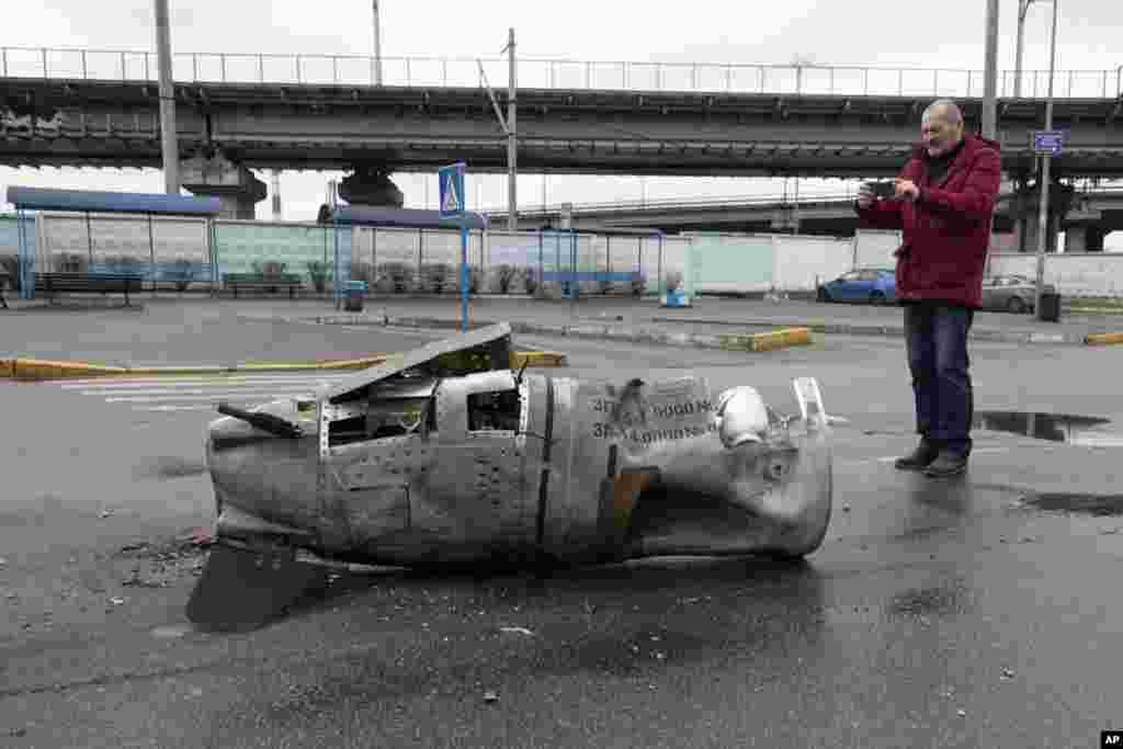 Un hombre toma una foto de los restos de un misil en una calle del distrito Vydubychi de Kiev, Ucrania, el viernes 4 de marzo de 2022.&nbsp;