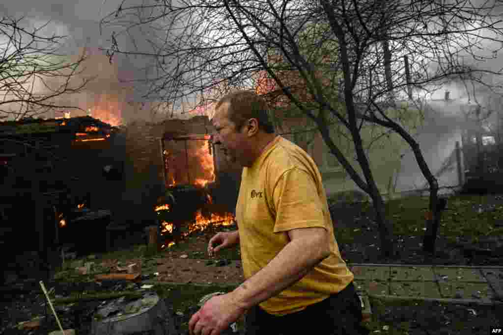 Yevghen Zbormyrsky, 49, runs in front of his burning house after being shelled in the city of Irpin, outside Kyiv, Ukraine.