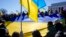 FILE - People hold a large Ukrainian national flag as they gather for a vigil in solidarity with Ukraine, at the Lincoln Memorial in Washington, Feb. 20, 2022.