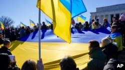 
지난달 20일 미국 워싱턴 D.C. 시내 링컨기념관 앞에서 열린 우크라이나 지지 집회 참가자들이 대형 우크라이나 국기를 들고 있다.
