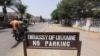 FILE - Men on a motorbike ride past a sign for the Ukrainian embassy in Abuja, Nigeria, Feb. 25, 2022.