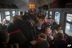 Mujeres y niños abarrotan un tren con destino a Lviv en la estación de Kiev, Ucrania, el jueves 3 de marzo de 2022. La invasión rusa de Ucrania ha obligado a más de un millón de personas a huir de su patria en solo una semana, un éxodo tan rápido que casi coincide el número de personas que buscaron refugio en Europa en todo un año durante la crisis migratoria de 2015. (Foto AP/Emilio Morenatti)