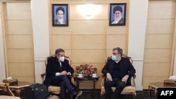 A handout picture provided by Atomic Energy Organization of Iran on March 4, 2022, shows AEOI spokesman Behrouz Kamalvandi, right, meeting with the head of the IAEA, Rafael Grossi, upon his arrival in Tehran. 