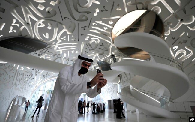 A man take a photo at the Museum of the Future, an exhibition space for innovative and futuristic ideas in Dubai, United Arab Emirates, Wednesday, Feb. 23, 2022. (AP Photo/Kamran Jebreili)