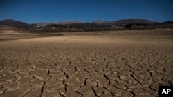 Part of the Vinuela reservoir is seen dry due to lack of rain in La Vinuela, southern Spain, Feb. 22, 2022. Declining agricultural yields and reduced water resources are key risks as global temperatures continue to rise. (AP Photo/Carlos Gil)