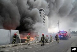Firefighters work to extinguish a fire at a damaged logistic center after shelling in Kyiv, Ukraine, March 3, 2022.