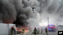 乌克兰消防人员正在基辅市为被攻击的后勤中心大楼灭火（2022年3月3日）