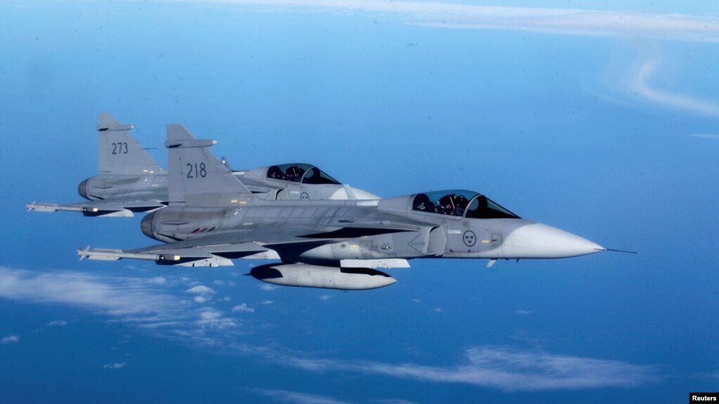 This file photo shows Sweden's Air Force "Grippen" fighters escorting a Lithuanian Air Force C-27J plane during NATO joint military exercise in Siauliai April 1, 2014. (REUTERS/Ints Kalnins)