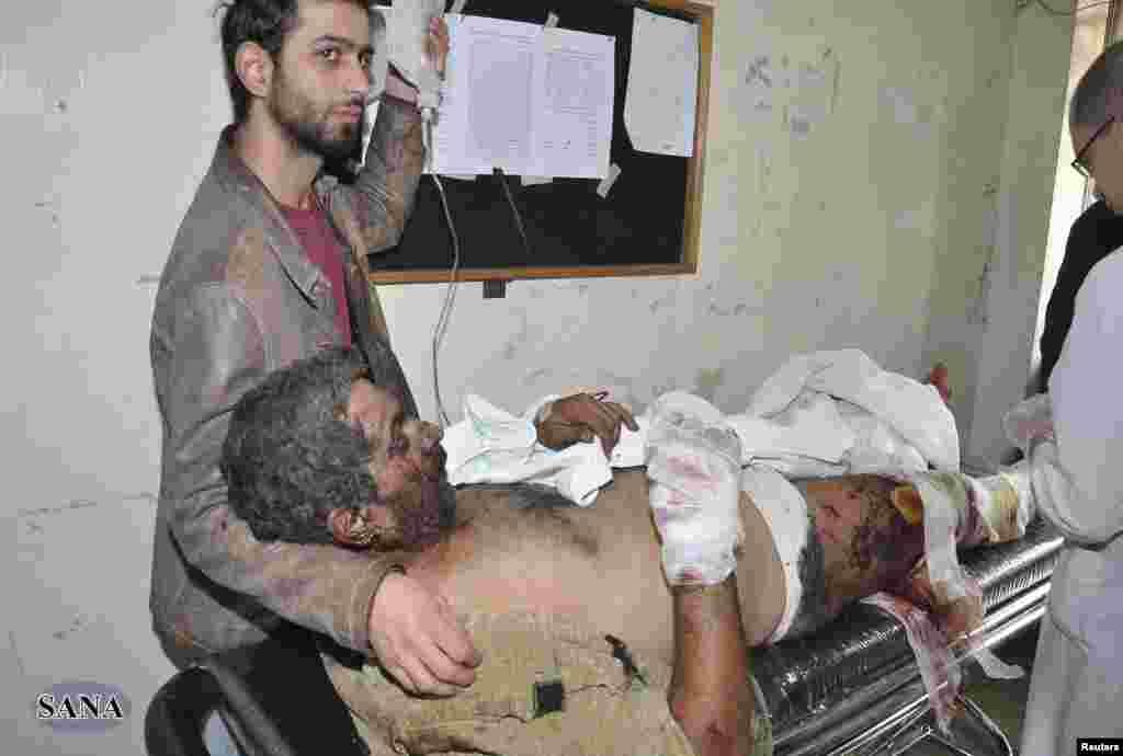 A man wounded in the explosions in Jaramana district, near Damascus, receives treatment at a hospital, in this handout photograph released by Syria&#39;s national news agency SANA, November 28, 2012. 