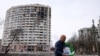 A man walks in front of a residential building damaged in yesterday's shelling in the city of Chernihiv on March 4, 2022.