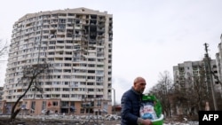 A man walks in front of a residential building damaged in yesterday's shelling in the city of Chernihiv on March 4, 2022.